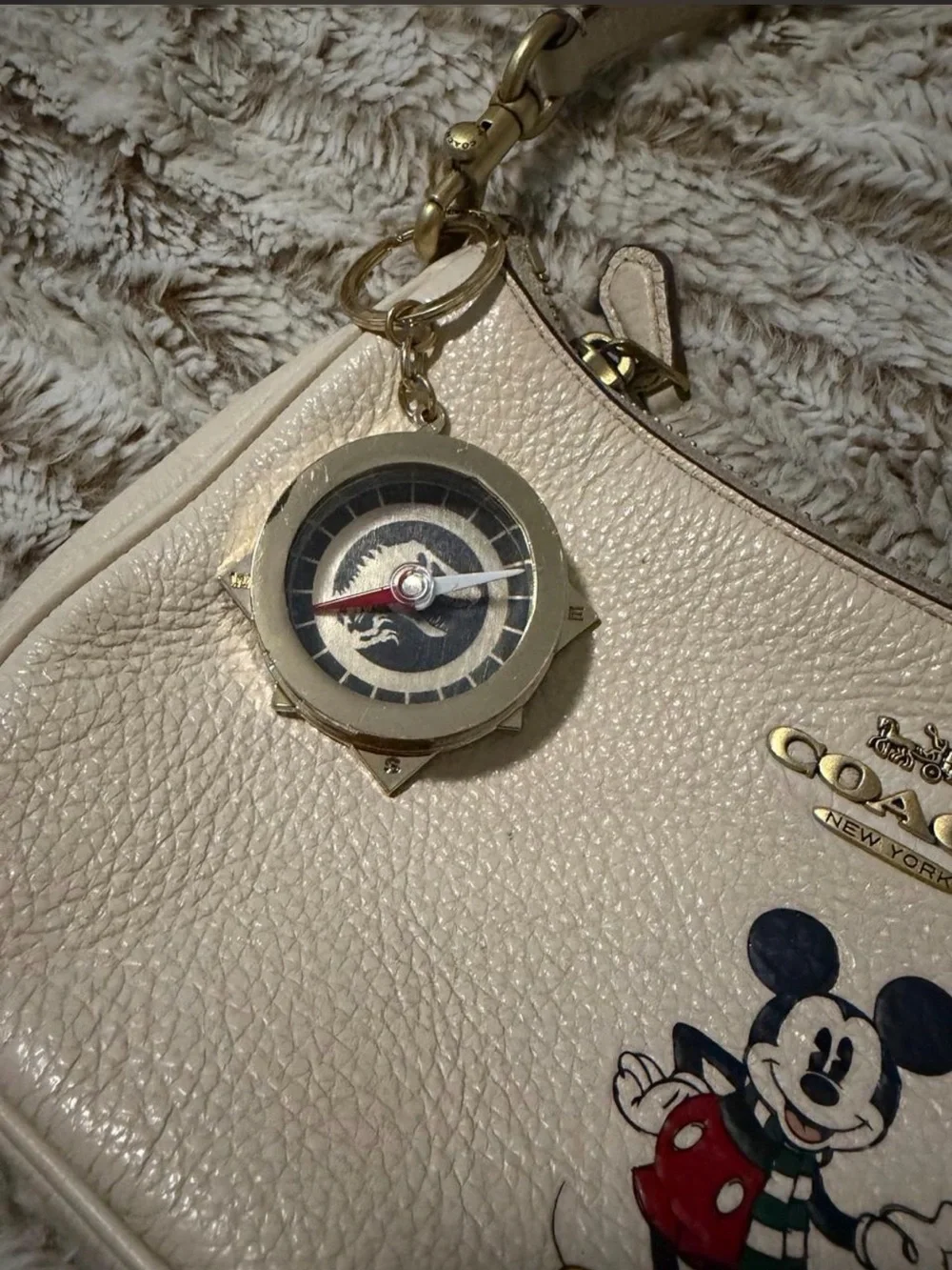 This Jurassic World compass keychain features the iconic T-Rex logo in gold-tone